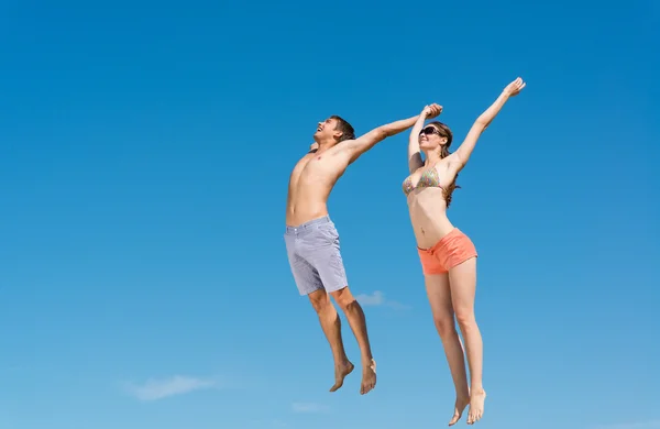 Casal jovem pulando juntos — Fotografia de Stock