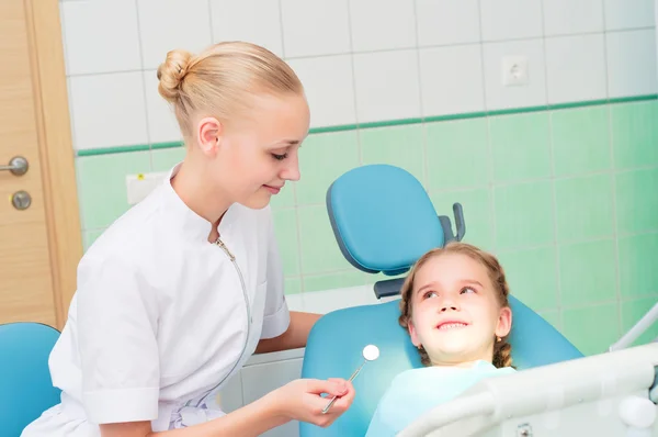 Joven médico mujer y niña en el consultorio del dentista — Foto de Stock