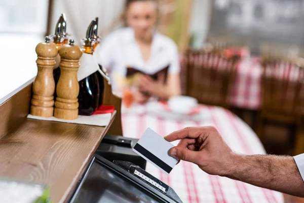 Waiter inserts the card into a computer terminal — Stock Photo, Image