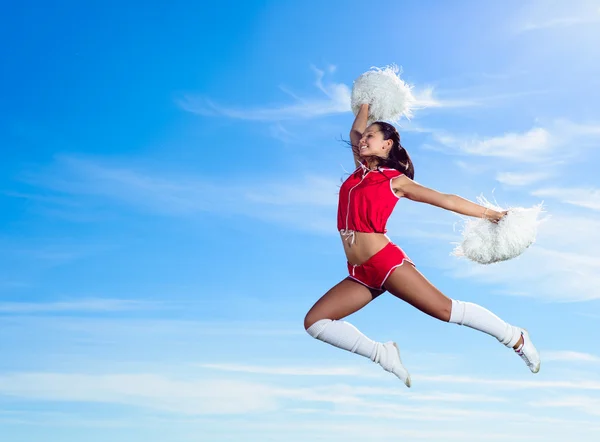 Jovem cheerleader em vermelho traje saltando — Fotografia de Stock
