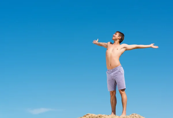 青い空を背景に上半身裸の男 — ストック写真