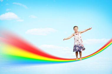 Girl jumping on clouds and a rainbow