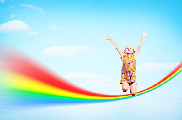 Ragazza che salta sulle nuvole e un arcobaleno — Foto Stock