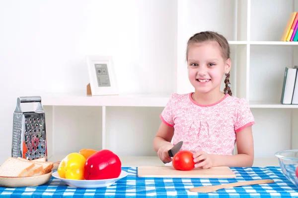 Chica trabajando en la cocina cortando verduras — Foto de Stock