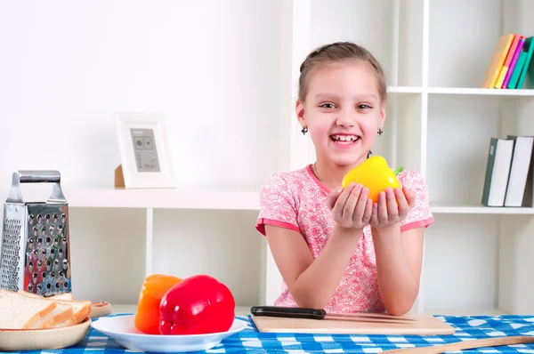 Meisje met groenten in de keuken — Stockfoto