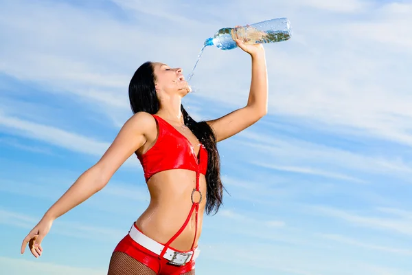 Sportmädchen in roter Uniform mit einer Flasche Wasser — Stockfoto