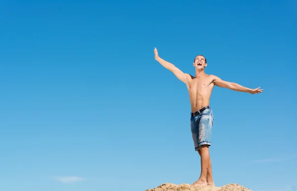 Hombre sin camisa contra el cielo azul — Foto de Stock