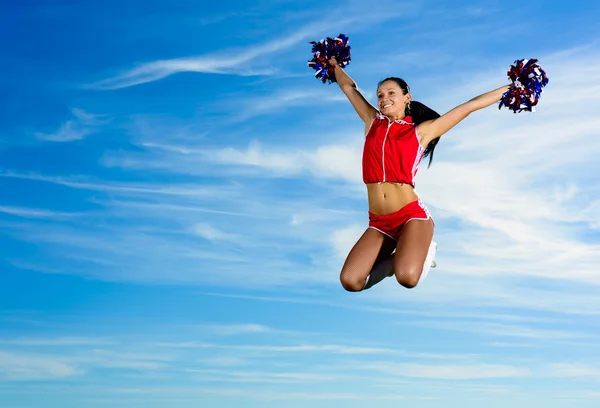 Jonge cheerleader in rood kostuum springen — Stockfoto