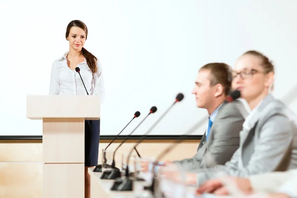 Zakenvrouw spreekt in een microfoon — Stockfoto