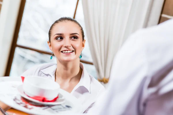 Ober brengt een schotel voor een mooie vrouw — Stockfoto