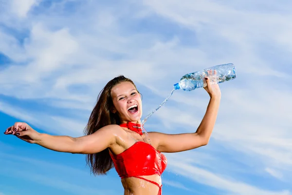 Sport girl in red uniform with a bottle of water — Stock Photo, Image