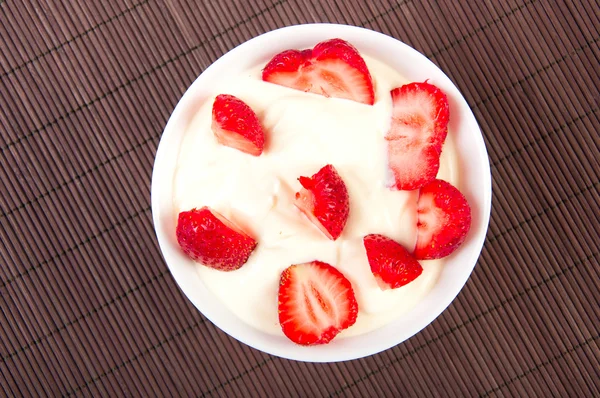 Strawberries with cream on bamboo tablecloth — Stock Photo, Image