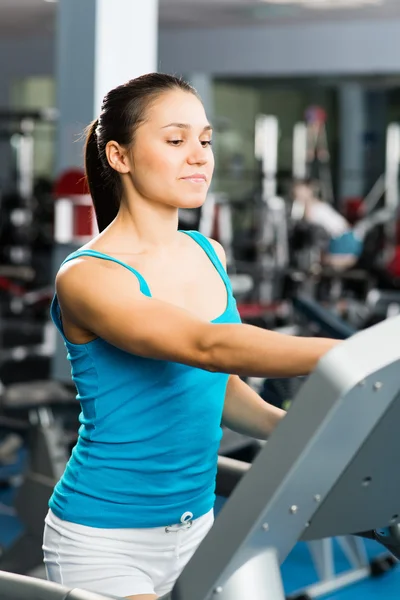 Attractive young woman adjusts the treadmill — Stock Photo, Image