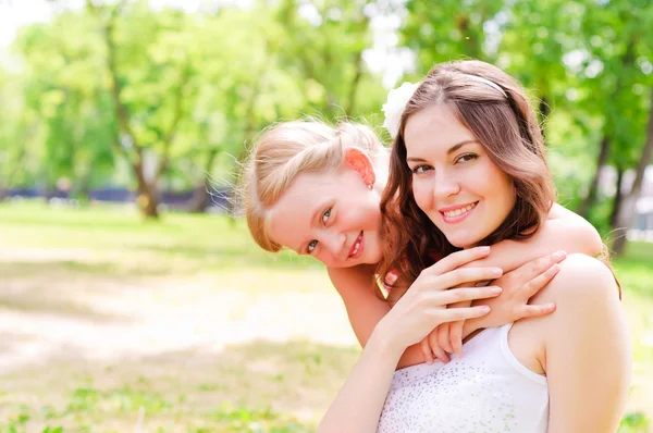 Moeder en dochter samen zitten op het gras — Stockfoto