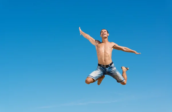 Homme sautant sur le fond bleu du ciel — Photo