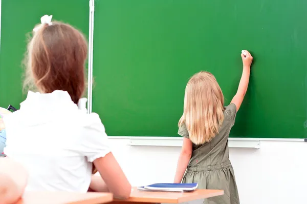 School girl writes on the blackboard — Stock Photo, Image