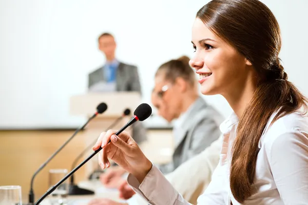 iş kadını bir mikrofona konuşur