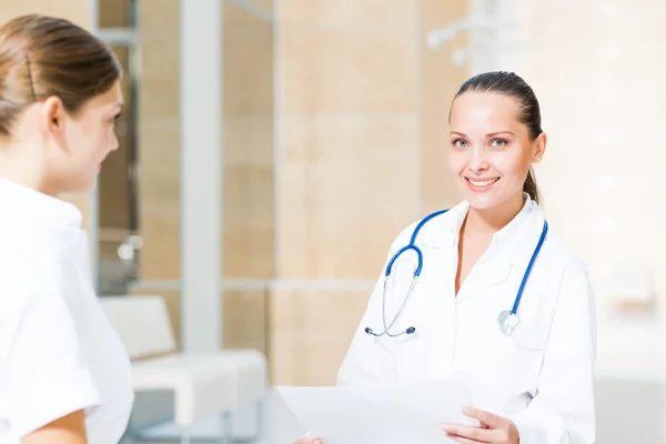 Two doctors talking in the lobby of the hospital — Stock Photo, Image