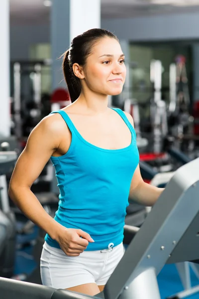 Mujer joven corriendo en una cinta de correr — Foto de Stock