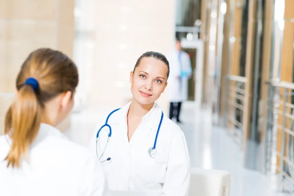 Two doctors talking in the lobby of the hospital — Stock Photo, Image