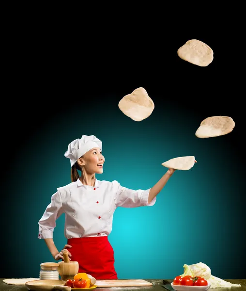 Chef juggling pieces pizza dough — Stock Photo, Image