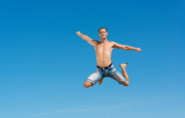 Homme sautant sur le fond bleu du ciel — Photo