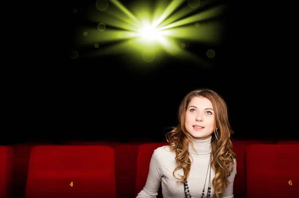 Jeune femme attrayante assise dans un cinéma — Photo