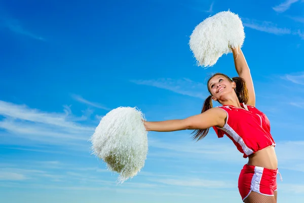 Młoda cheerleaderka w czerwony strój z pampon — Zdjęcie stockowe