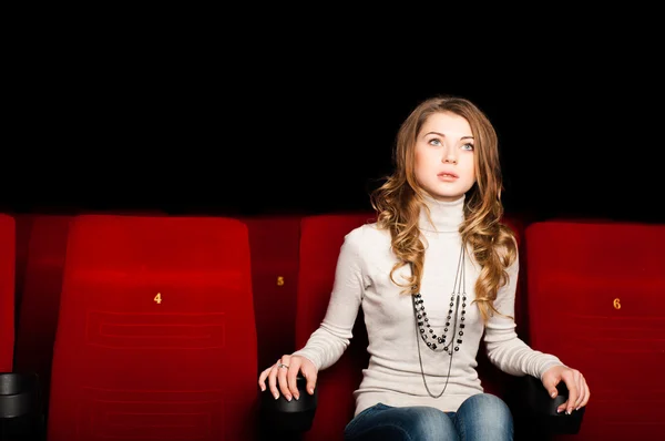 Mladá atraktivní žena sedící v kině — Stock fotografie