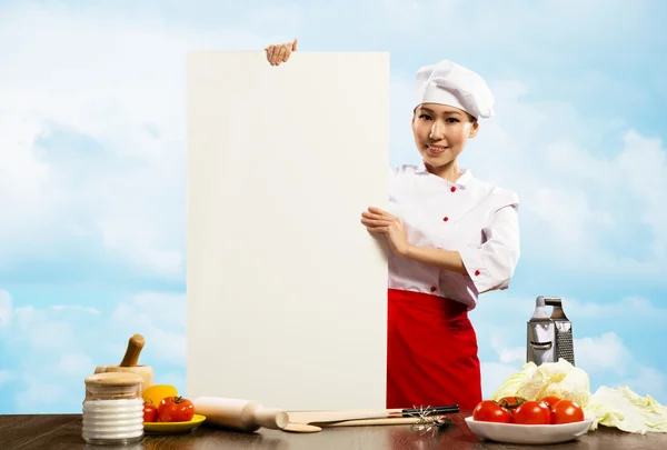 Ženské šéfkuchař drží plakát pro text — Stock fotografie