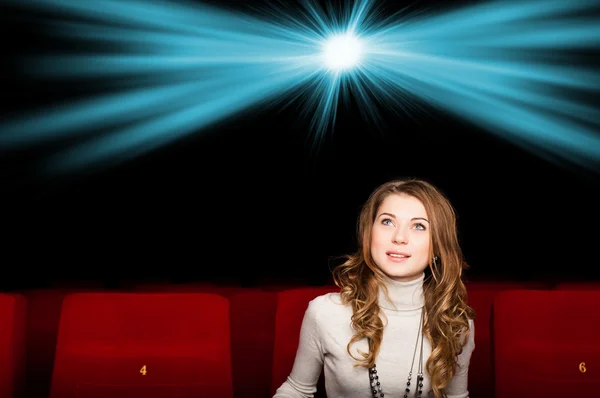 Ung attraktiv kvinna sitter i en biograf — Stockfoto