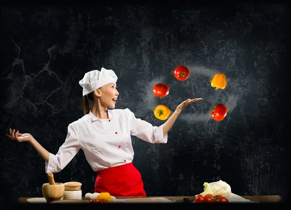 Mujer asiática cocinero malabares con verduras —  Fotos de Stock