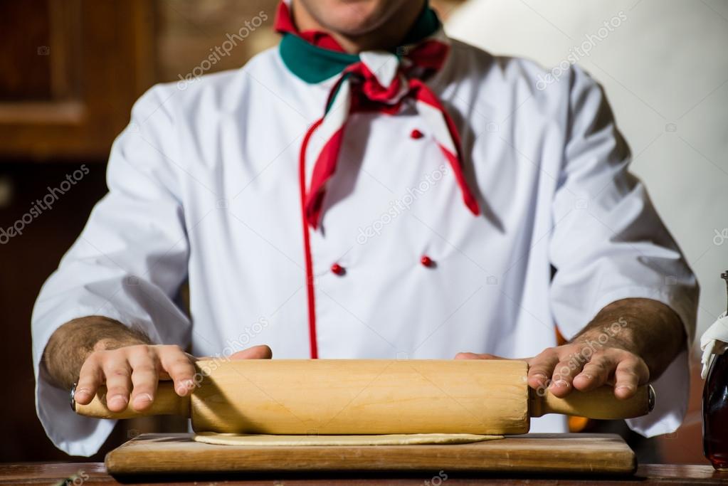 Cook rolls out the dough on a board