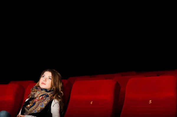 Joven mujer atractiva sentada en un cine — Foto de Stock