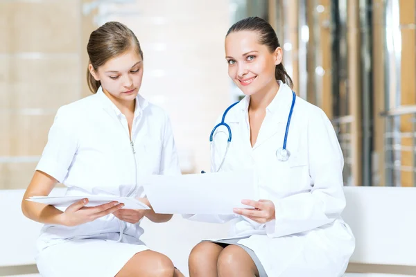 Two doctors talking in the lobby of the hospital — Stock Photo, Image
