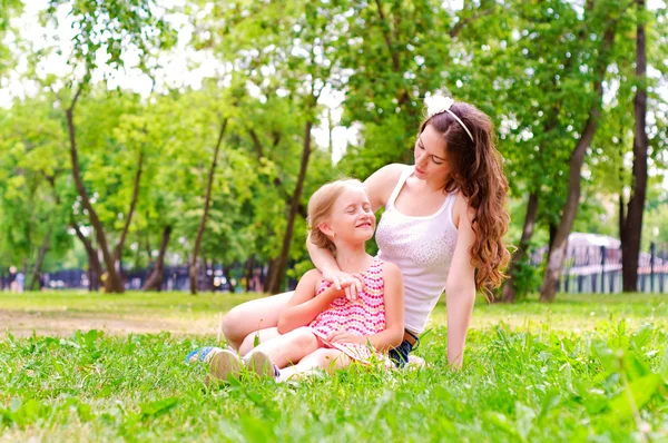 Moeder en dochter samen zitten op het gras — Stockfoto