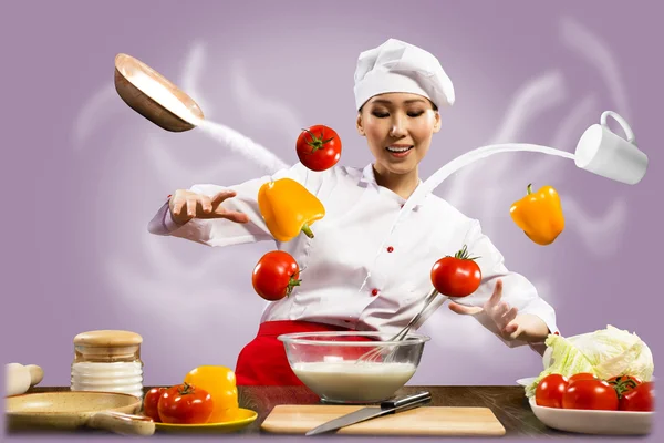 Asian female chef in the kitchen conjures — Stock Photo, Image