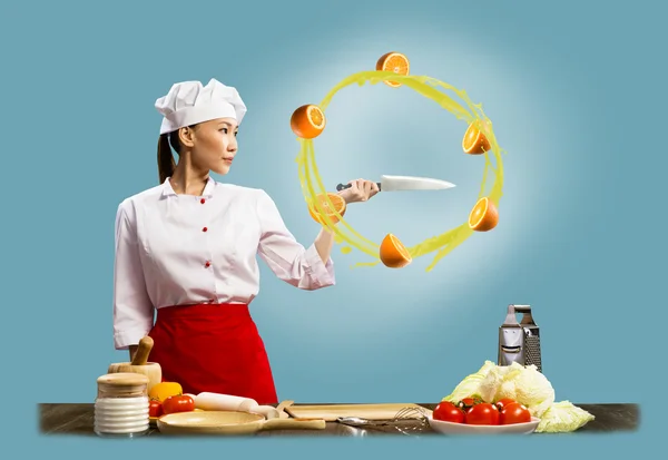 Asian female chef slicing oranges — Stock Photo, Image