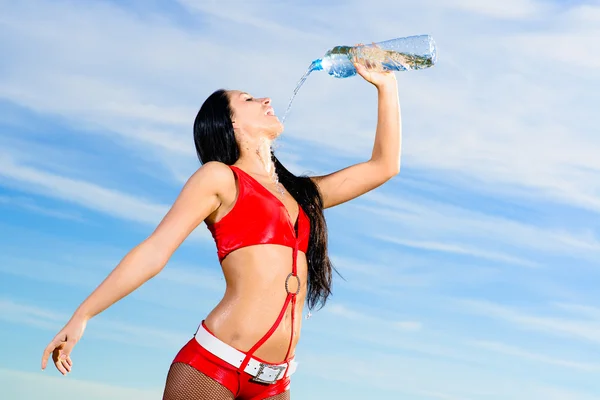 Ragazza sportiva in uniforme rossa con una bottiglia d'acqua — Foto Stock