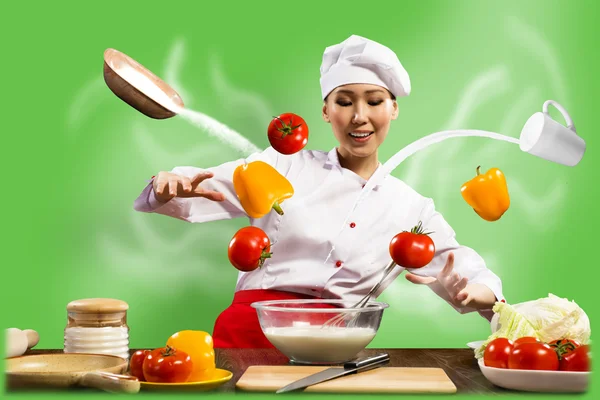 Asian female chef in the kitchen conjures — Stock Photo, Image