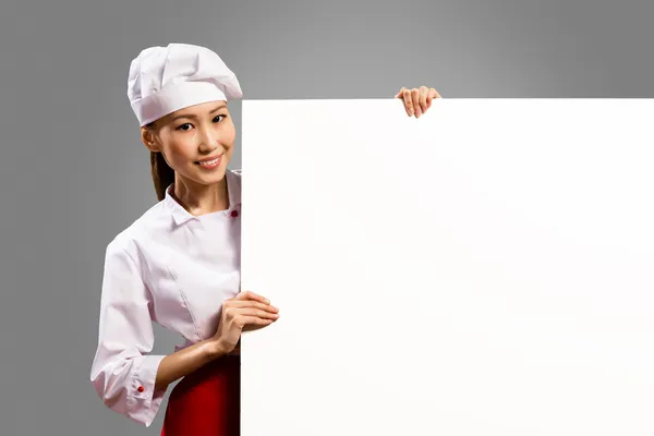 Asiatiska kvinnliga kock håller affisch för texten — Stockfoto