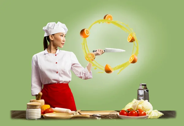 Asian female chef slicing oranges — Stock Photo, Image