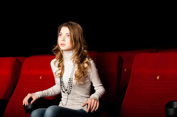 Young attractive woman sitting in a cinema — Stock Photo, Image