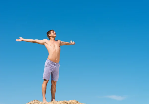 Homem sem camisa contra o céu azul — Fotografia de Stock