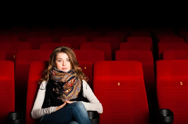 Jovem mulher atraente sentada em um cinema — Fotografia de Stock