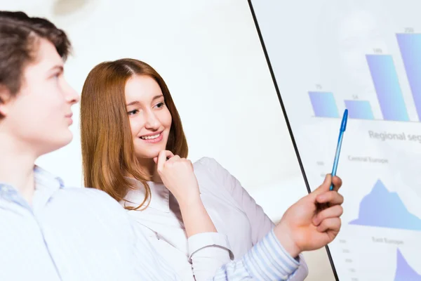 Zakenvrouw met een collega verslagen bespreken — Stockfoto