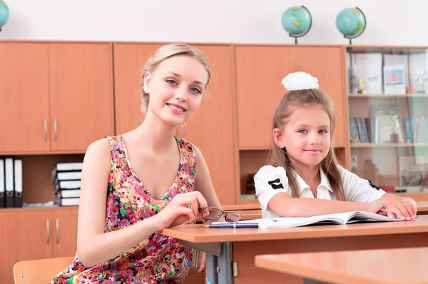 Teacher sitting near pupil — Stock Photo, Image