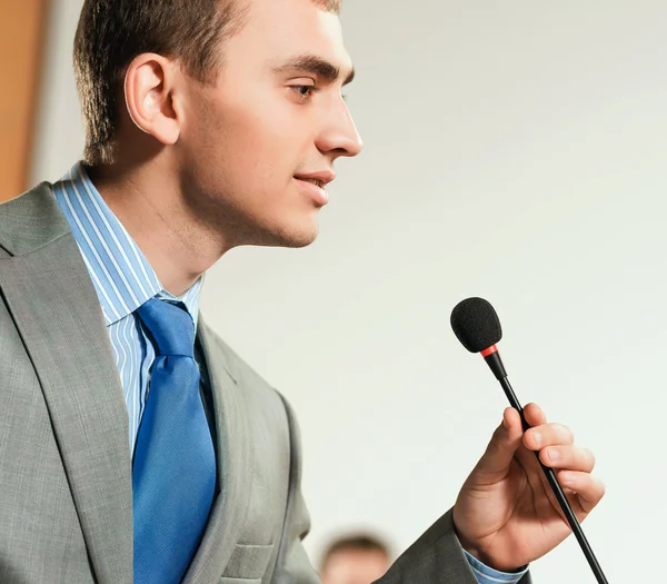 Portrait of a business man holding microphone — Stock Photo, Image