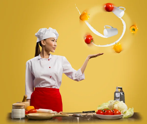 Mujer asiática cocinero malabares con verduras —  Fotos de Stock