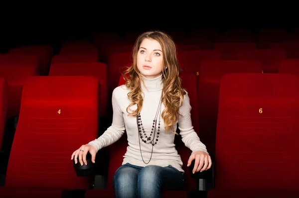 Young attractive woman sitting in a cinema — Stock Photo, Image